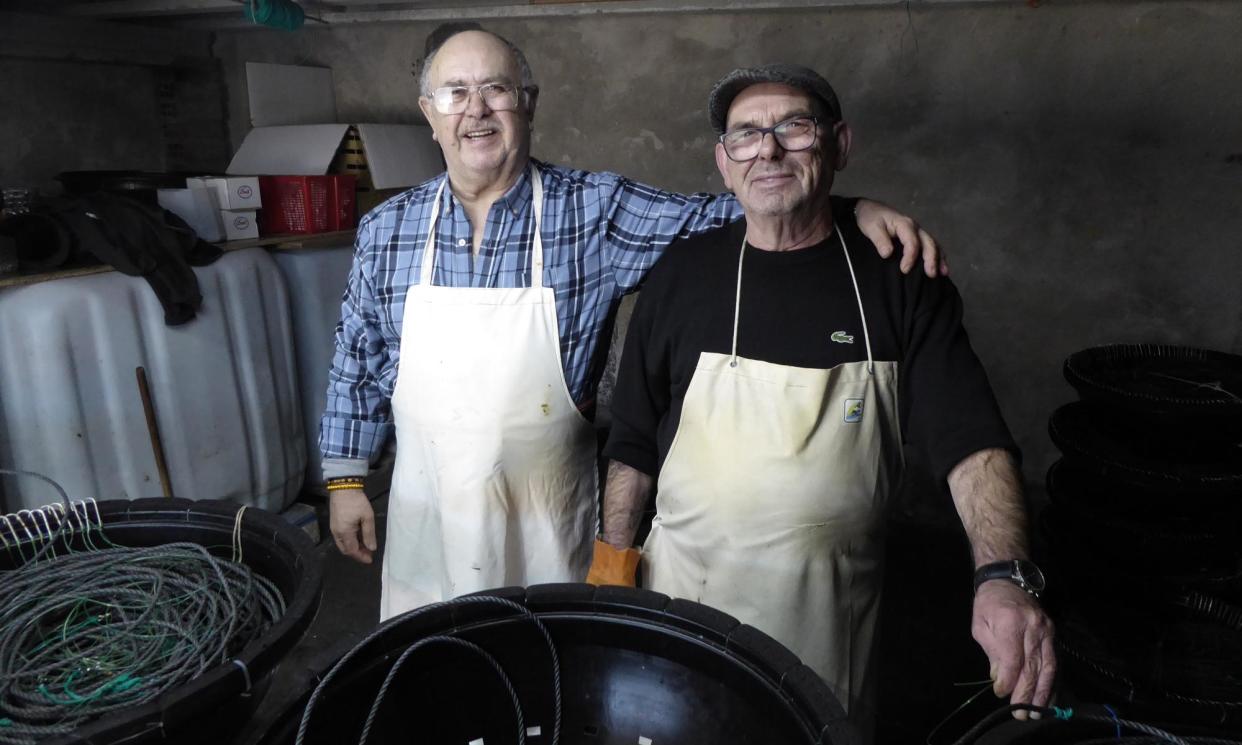 <span>Former sailors Sito Mendoza, left, and Ramón Álvarez now work in the conger eel business from a wharfside shed in Fisterra, Galicia.</span><span>Photograph: Sam Jones</span>