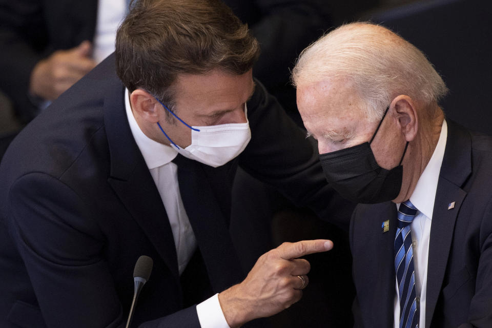 U.S. President Joe Biden, right, speaks with French President Emmanuel Macron during a plenary session during a NATO summit at NATO headquarters in Brussels, Monday, June 14, 2021. U.S. President Joe Biden is taking part in his first NATO summit, where the 30-nation alliance hopes to reaffirm its unity and discuss increasingly tense relations with China and Russia, as the organization pulls its troops out after 18 years in Afghanistan. (Brendan Smialowski, Pool via AP)