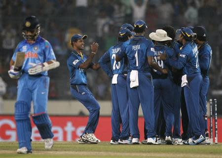 Ajinkya Rahane (L) leaves the field as Sri Lanka's fielders celebrate his dismissal during their ICC Twenty20 World Cup cricket final match at the Sher-E-Bangla National Cricket Stadium in Dhaka April 6, 2014. REUTERS/Andrew Biraj