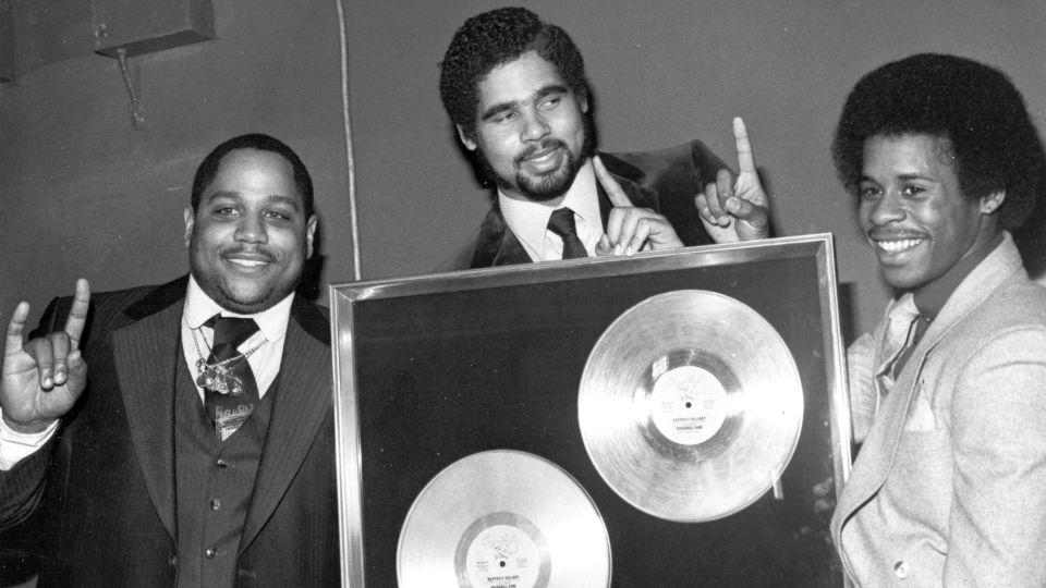 The Sugar Hill Gang (members left to right: Big Bank Hank, Wonder Mike and Master G), pictured circa 1980 with their gold record for "Rapper's Delight," the song largely credited with sending hip-hop around the world. - Michael Ochs Archives/Getty Images