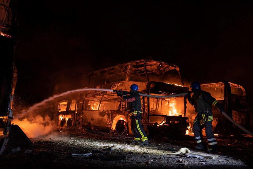 Firefighters put out fire caused by fragments of a Russian rocket after it was shot down by air-defense systems during an attack in Kyiv on May 16, 2023.