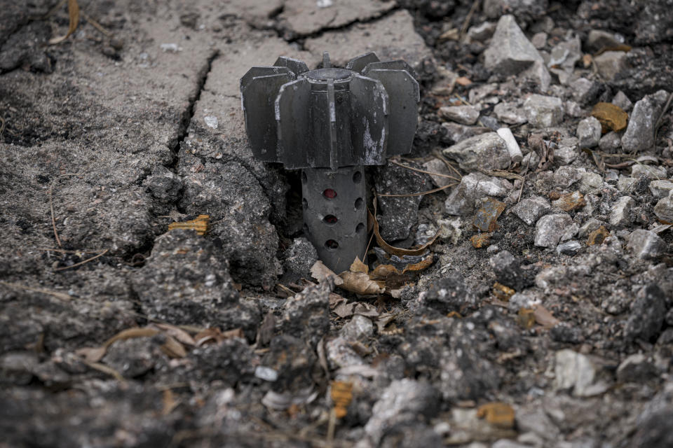 A part of a mortar shell sticks out of the asphalt in Stoyanka, Ukraine, Sunday, March 27, 2022. (AP Photo/Vadim Ghirda)