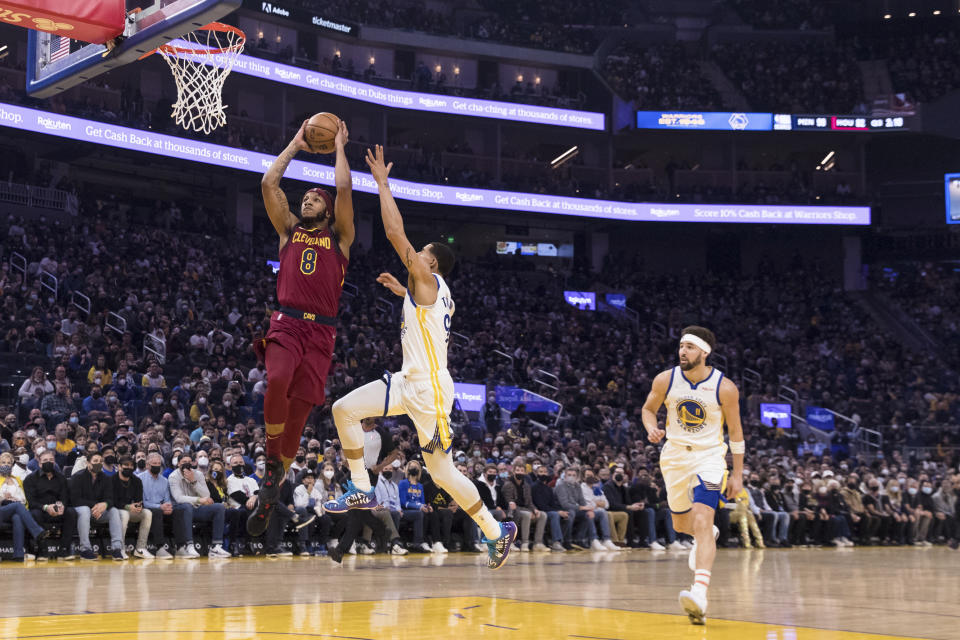 Cleveland Cavaliers forward Lamar Stevens (8) goes up to dunk in front of Golden State Warriors forward Juan Toscano-Anderson, center, and guard Klay Thompson (11) during the first half of an NBA basketball game in San Francisco, Sunday, Jan. 9, 2022. (AP Photo/John Hefti)