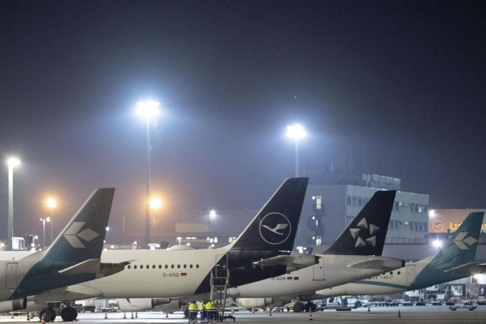 Passenger planes are parked at Frankfurt Airport, Germany, early Wednesday, Jan. 17, 2024. Heavy snowfalls and freezing rain across Germany Wednesday led to the cancellation of hundreds of flights and trains, crashes on icy roads, and school closures. (Boris Roessler/dpa via AP)