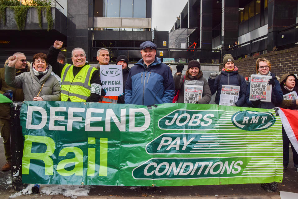 LONDON, UNITED KINGDOM - 2022/12/13: RMT (Rail, Maritime, and Transport Workers Union) General Secretary Mick Lynch (C) stands with union members behind a banner which states 'Defend rail jobs, pay, conditions' at the picket line outside Euston Station as fresh rail strikes hit the UK. (Photo by Vuk Valcic/SOPA Images/LightRocket via Getty Images)