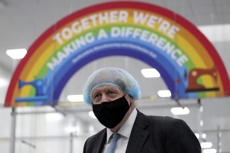 Britain's Prime Minister Boris Johnson, wearing a face mask to prevent the spread of the coronavirus, visits a PPE manufacturing facility during a visit to the north east of England, in Seaton Delaval, England, Saturday, Feb. 13, 2021. (AP Photo/Scott Heppell, Pool)
