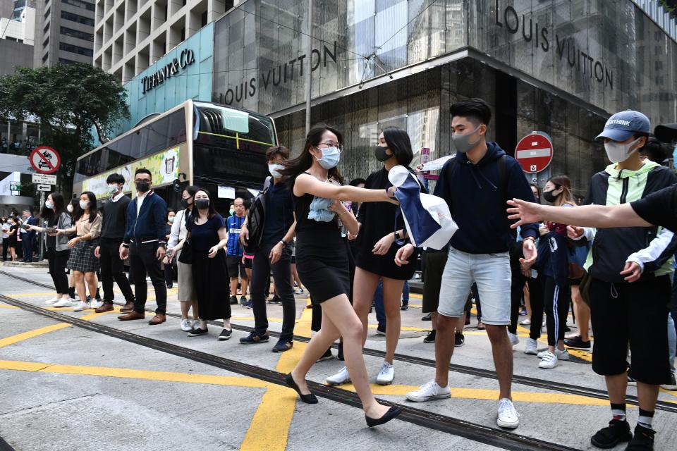 Office workers and pro-democracy protesters form a human chain to pass bricks during a demonstration in Central in Hong Kong on November 12, 2019. | ANTHONY WALLACE—AFP via Getty Images