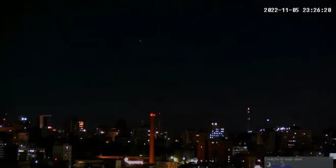 Uma das luzes aparece na parte superior da imagem, próxima do centro (Imagem: Reprodução/Canal Câmera Pôr do Sol Guaíba0