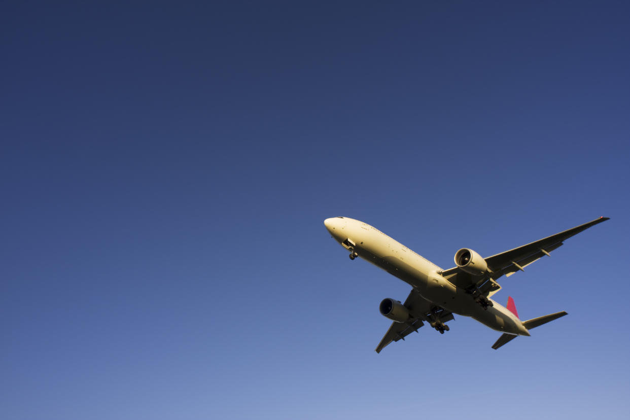 Commercial airplane flying overhead and copy space