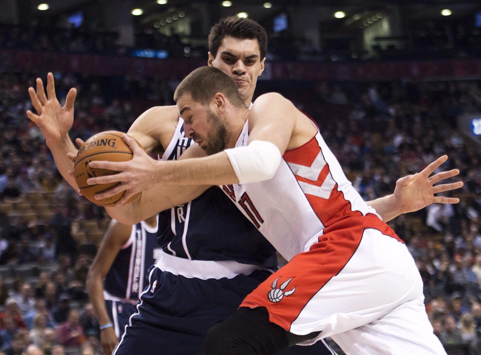 Toronto Raptors forward Jonas Valanciunas, front, tries to drive past Oklahoma Thunder forward Steven Adams during the first half of an NBA basketball game in Toronto on Friday, March 21, 2014. (AP Photo/The Canadian Press, Nathan Denette)