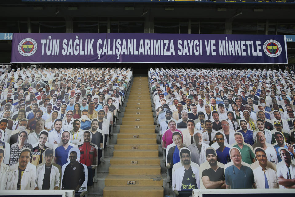 A view of cardboards with photographs of medical staff on the stands prior to a Turkish Super League soccer match between Fenerbahce and Kayserispor in Istanbul, Friday, June 12, 2020. The banner reads in Turkish: 'To all our medical staff with respect and gratefulness'. The Turkish Super Lig resumed its season on Friday without spectators after it had suspended games since March 20 due to the coronavirus pandemic, later than many other European leagues. (Erdem Sahin/Pool via AP)