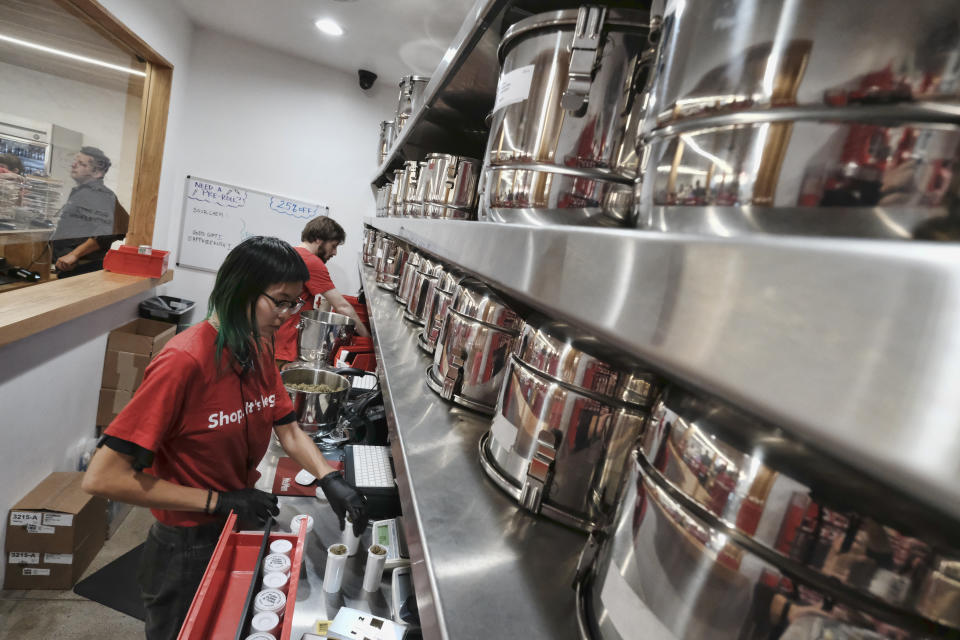 FILE - In this Jan. 12, 2018, file photo, a bud tender prepares marijuana for a customer at Med Men a dispensary in West Hollywood, Calif. Leading California cannabis companies Friday, Dec. 17, 2021, warned Gov. Gavin Newsom that the state's legal industry was on the verge of collapse and needed immediate tax cuts and a rapid expansion of retail outlets to steady the marketplace. (AP Photo/Richard Vogel,Ffile)