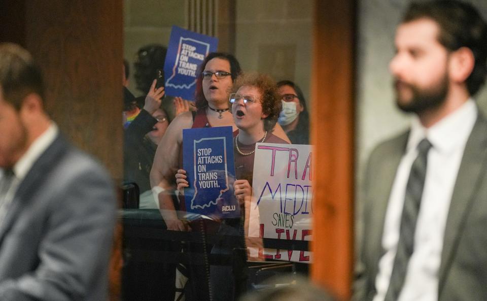 Demonstrators rally outside the Indiana Senate Chamber on Wednesday, Feb. 22, 2023, as the Senate Health and Provider Services Committee hears SB 480 at the Statehouse in Indianapolis. The bill, which passed committee 8-3, would ban gender-affirming medical or surgical treatment for minors.