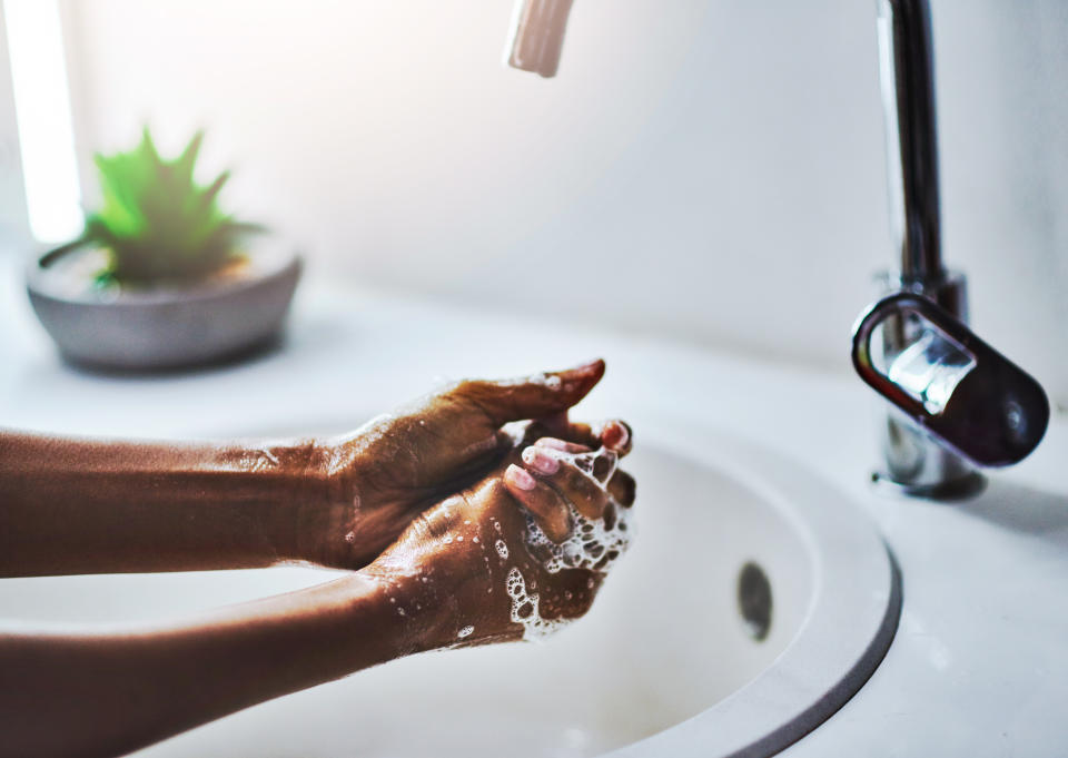 When washing your hands, scrub for at least 20 seconds with warm, soapy water. Don't miss your thumbs, fingertips, and in between fingers. Then dry your hands off. (Photo: Delmaine Donson via Getty Images)