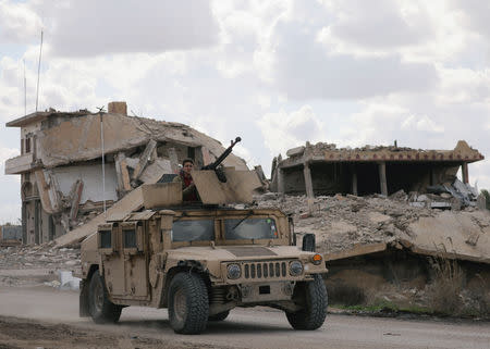 A fighter from the Syrian Democratic Forces (SDF) rides on a vehicle in the village of Baghouz, Deir Al Zor province, Syria February 18, 2019. REUTERS/Rodi Said