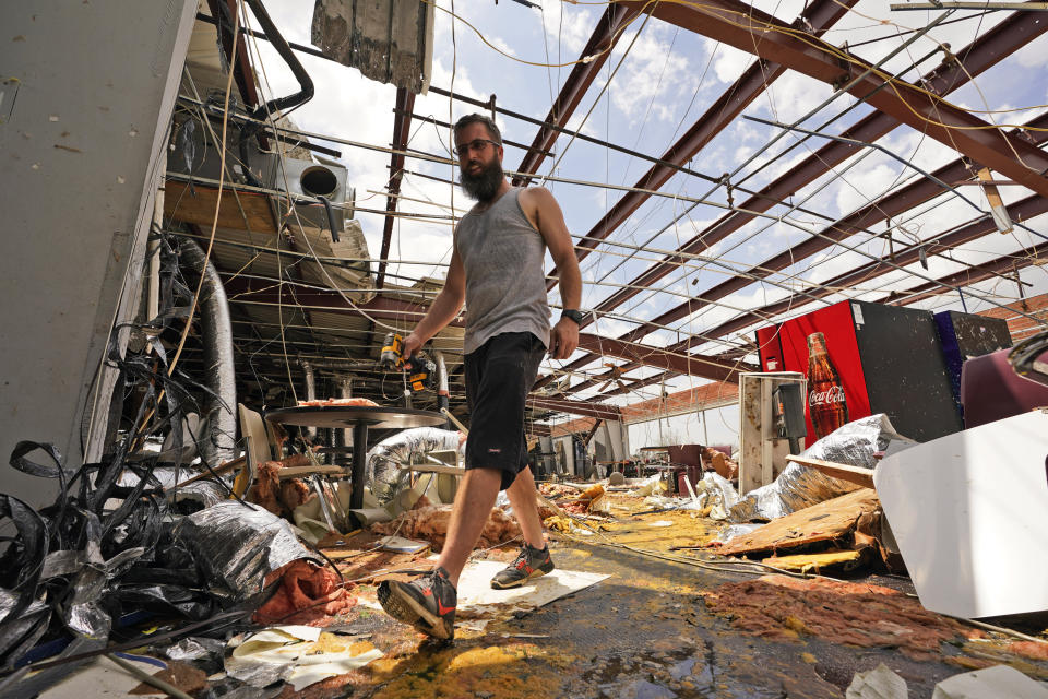 Jason Ledet relieves a tool as he works in a destroyed bowling alley as they try to recover from the effects of Hurricane Ida Tuesday, Aug. 31, 2021, in Houma, La. (AP Photo/Steve Helber)