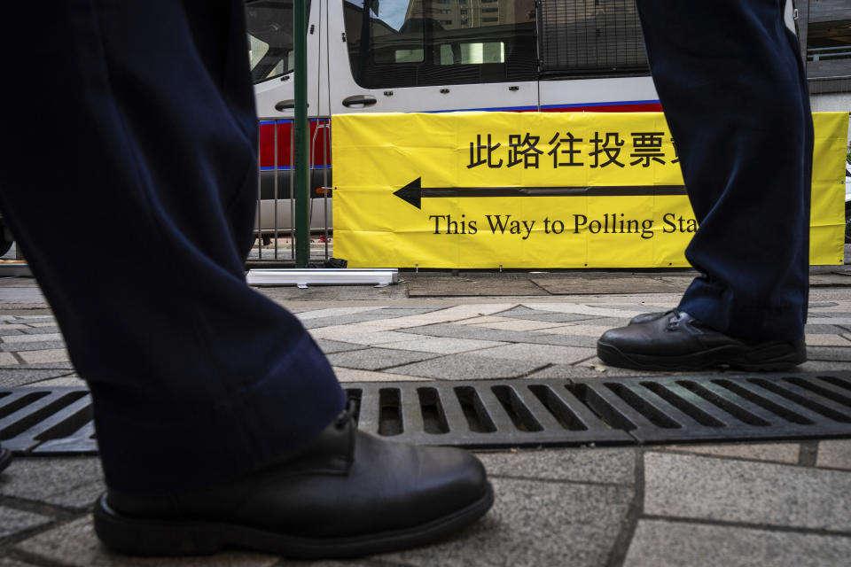 Police officers patrol outside a polling station during the District Council elections in Hong Kong, Sunday, Dec. 10, 2023. Residents went to the polls on Sunday in Hong Kong's first district council elections since an electoral overhaul was implemented under Beijing's guidance of “patriots” administering the city, effectively shutting out all pro-democracy candidates. (AP Photo/Louise Delmotte)