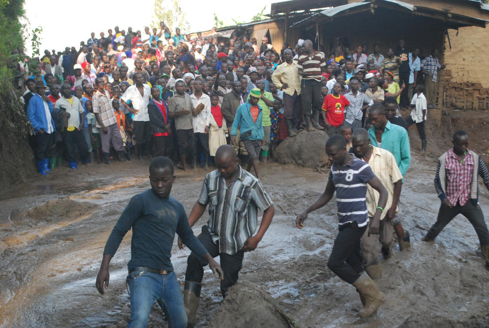 Residence look for survivors at a river filled with mud in Bududa District, Uganda, Friday, Oct. 12, 2018. At least 30 people died in mudslides triggered by torrential rains in a mountainous area of eastern Uganda that is prone to such disasters, a Red Cross official said Friday. More victims were likely to be discovered when rescue reams access all the affected areas in the foothills of Mount Elgon, said Red Cross spokeswoman Irene Nakasiita. (AP Photo/ Ronald Kabuubi)