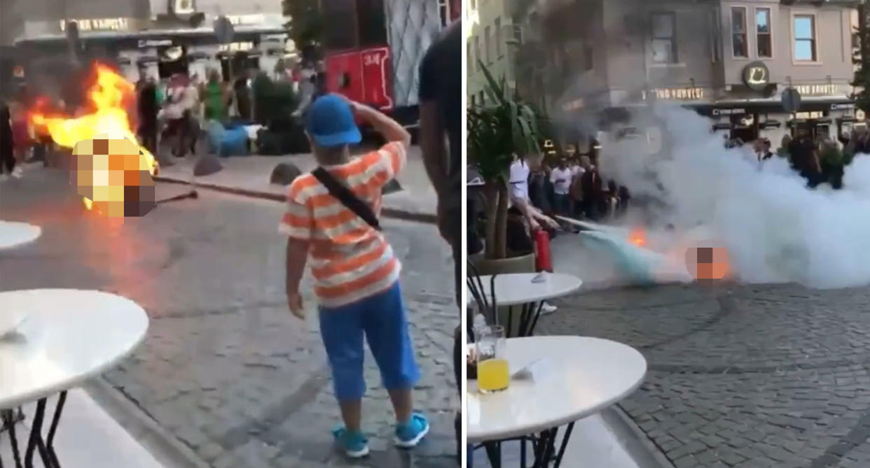 Stunned bystanders, including children, watch on as the man burns in the middle of the street. Source: Twitter