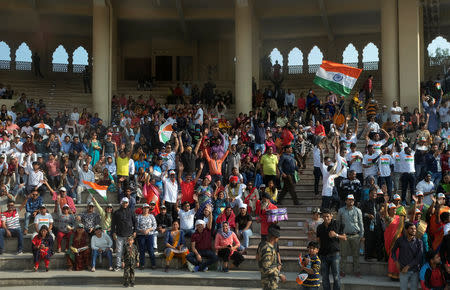 FILE PHOTO: Indian spectators at a stadium at the Wagah-Attari border crossing cheer the 'friendship bus' as it crosses into Pakistan, March 15, 2019. REUTERS/Alasdair Pal