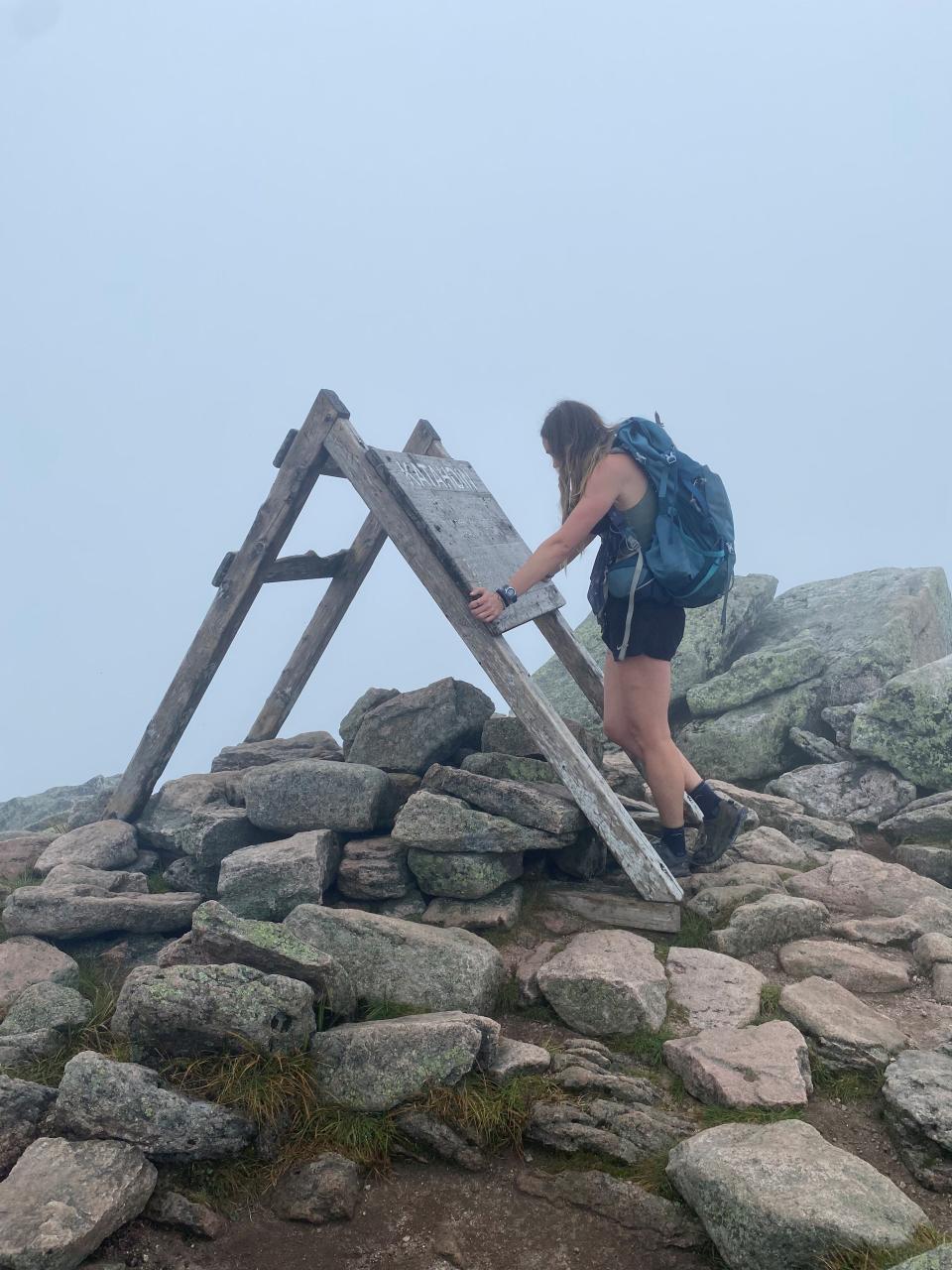 Alexis Holzmann reads the sign at the summit of Mount Katahdin in Maine, which indicates the finish line of the Appalachian Train. The Poughkeepsie native hiked along the 2,200-mile course for six months, completing the journey on Aug. 30, 2023.