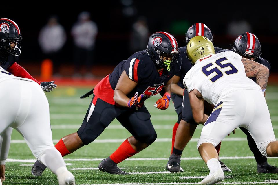 Aliquippa's Neco Eberhardt looks to land a block on Bishop McDevitt's Riley Robell during a play Thursday night in the PIAA Class 4A championship game in Mechanicsburg.