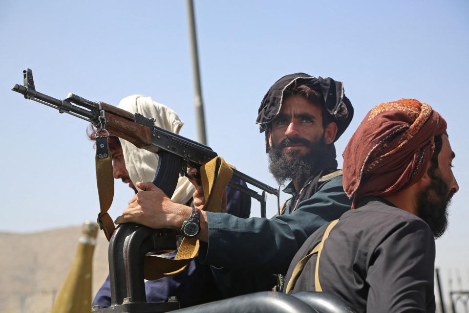 Taliban fighters stand guard in a vehicle along the roadside in Kabul on August 16, 2021, after a stunningly swift end to Afghanistan's 20-year war, as thousands of people mobbed the city's airport trying to flee the group's feared hardline brand of Islamist rule. (- /AFP via Getty Images)