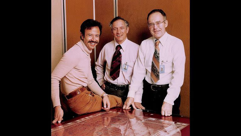 Andy Grove, Robert Noyce y Gordon Moore; según la Web de Intel, la foto es de 1978, pero sobre la mesa se ve el plano de un 8080, un microprocesador de 1974. Michael Malone aclara el punto en su libro The Intel Trinity: la foto fue tomada en realidad en 1975