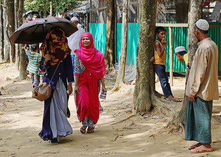 Formin Akter, a Rohingya refugee girl, walks with her friend Shahima through a refugee camp as she departs for Chittagong to attend school at the Asian University for Women, in Cox's Bazar, Bangladesh, August 24, 2018. Picture taken August 24, 2018. REUTERS/Mohammad Ponir Hossain