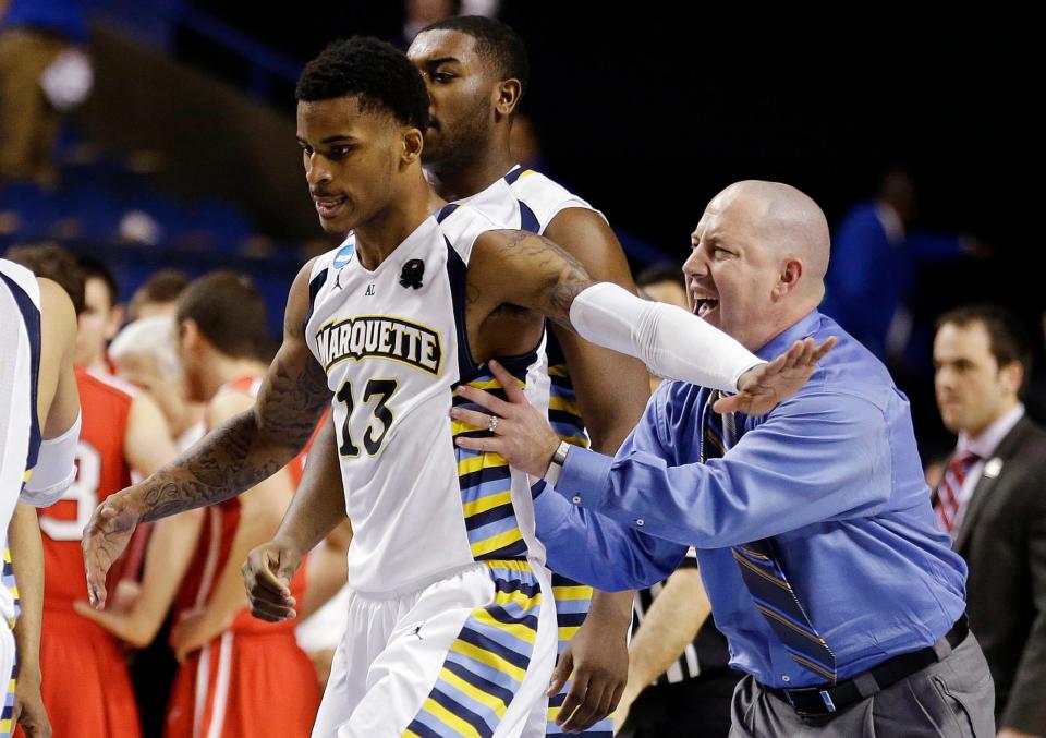 Marquette guard Vander Blue (13) and head coach Buzz Williams celebrate after Blue hit the winning basket against Davidson with one second left in their second-round NCAA college basketball tournament game, Thursday, March 21, 2013, in Lexington, Ky. Marquette won 59-58.