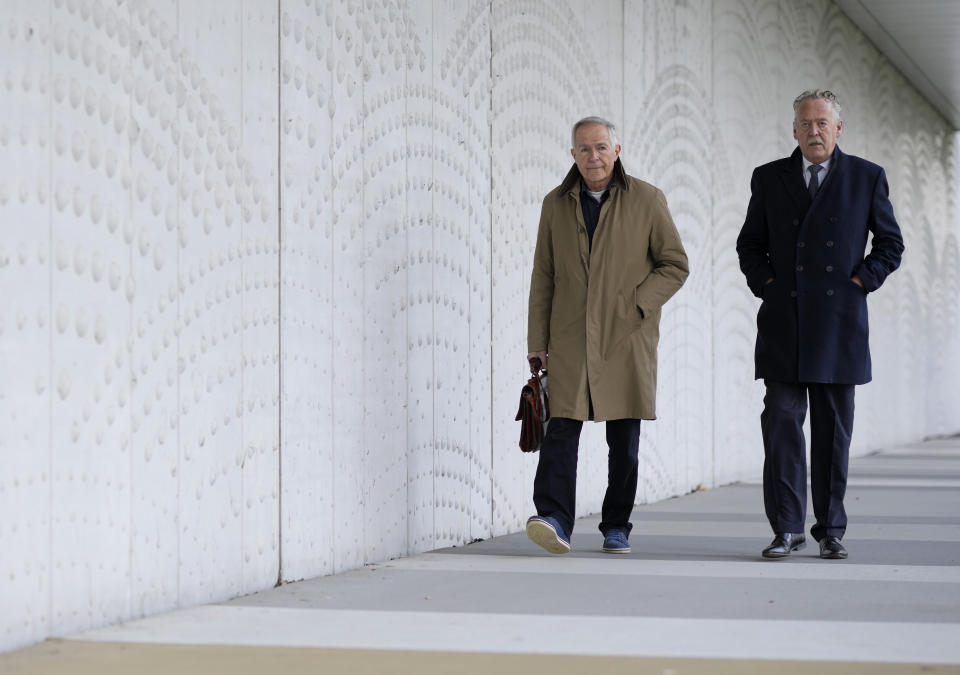 Anton Kotte, left, who lost his son, daughter-in-law and grandson and Piet Ploeg, who lost his brother, sister-in-law and nephew arrive outside the court for the ongoing trial and criminal proceedings regarding the downing of Malaysia Airlines flight MH17, at the high security court at Schiphol airport, near Amsterdam, Netherlands, Monday Dec. 20, 2021. Prosecutors are scheduled to begin explaining evidence and their case to judges Monday in the murder trial of three Russians and a Ukrainian charged with involvement in downing Malaysia Airlines flight MH17 over eastern Ukraine in 2014, killing all 298 passengers and crew. (AP Photo/Peter Dejong)