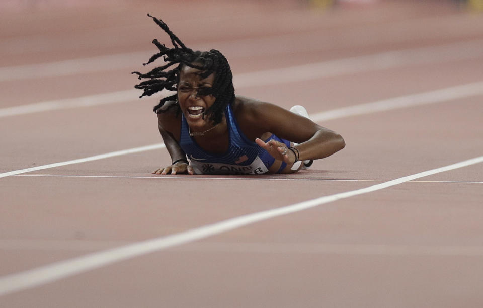 English Gardner, of the United States hits the track in frustration after pulling up injured in the women's 100 meter semifinal at the World Athletics Championships in Doha, Qatar, Sunday, Sept. 29, 2019. (AP Photo/Petr David Josek)