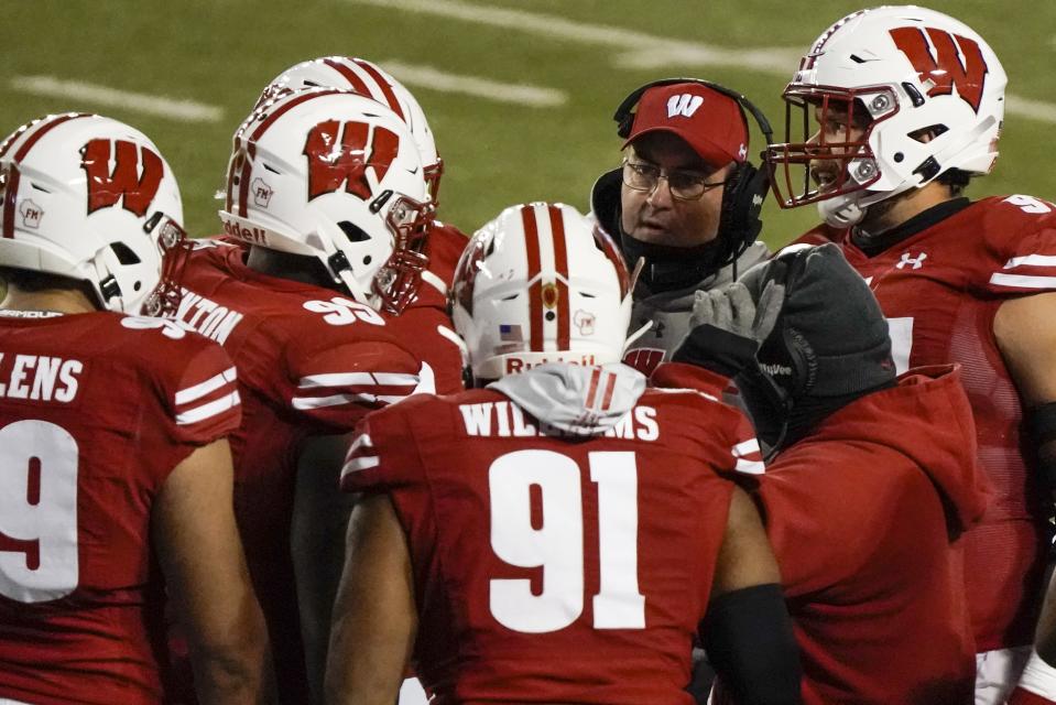 Wisconsin head coach Paul Chryst talks to his players during the first half of an NCAA college football game against Illinois Friday, Oct. 23, 2020, in Madison, Wis. (AP Photo/Morry Gash)
