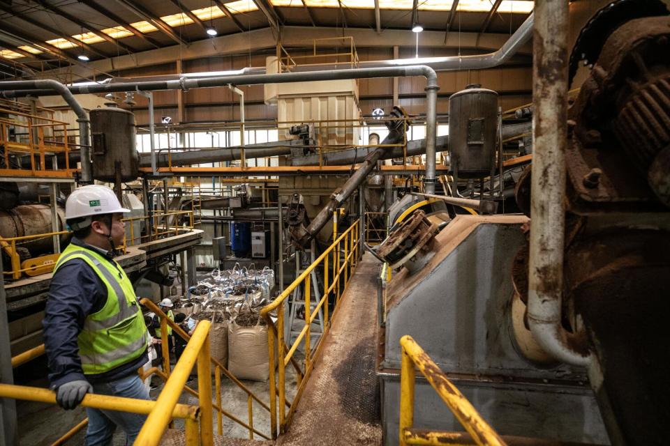 An employee of Reclean, at left, stands amidst the food processing machines.