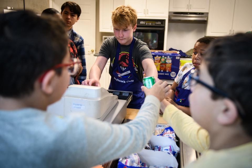 Liam Clark, center, rings up a beverage for a couple of his fellow students at School of Hope’s new student run cafe, Skyhawk Cafe, on Friday, March 22, 2024.