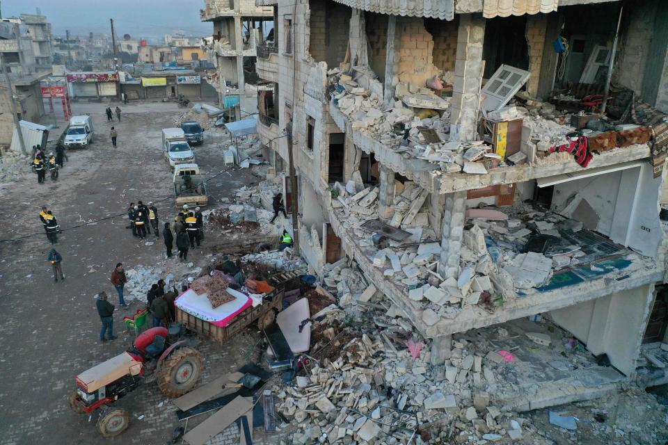 An aerial view shows a family retrieving their belongings from a damaged building in the rebel-held town of Jindayris on Feb. 9, 2023, three days after a deadly earthquake that hit Turkey and Syria.