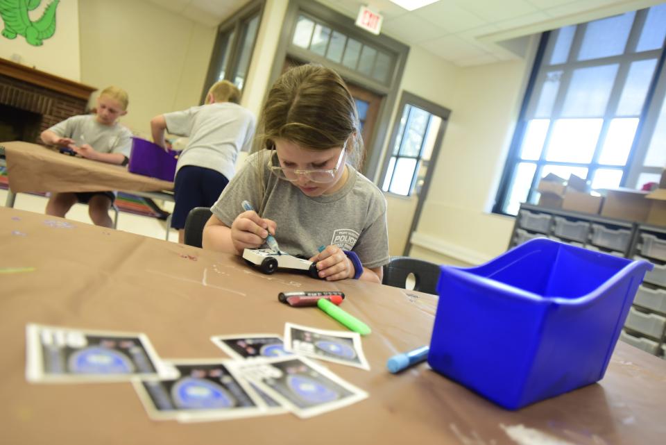 Amelia Bergman decorates her pinewood derby car during the Port Huron Police Department's annual Law Enforcement Elementary Camp on Wednesday, June 22, 2022, at Garfield Elementary School.