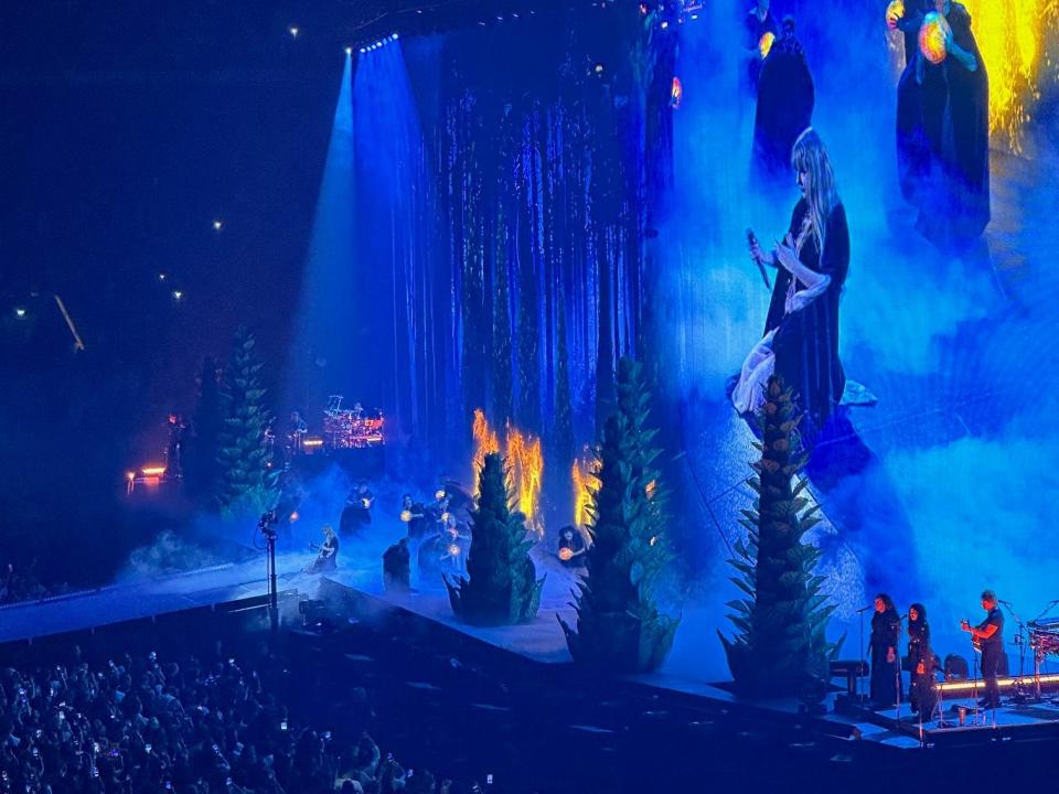 Taylor Swift on stage with evergreen trees