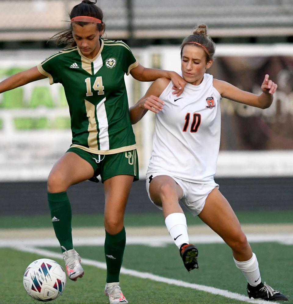 GlenOak's Adrianna White moves the ball under pressure from Green's Molly Rutherford, Wednesday, Sept 20, 2023.