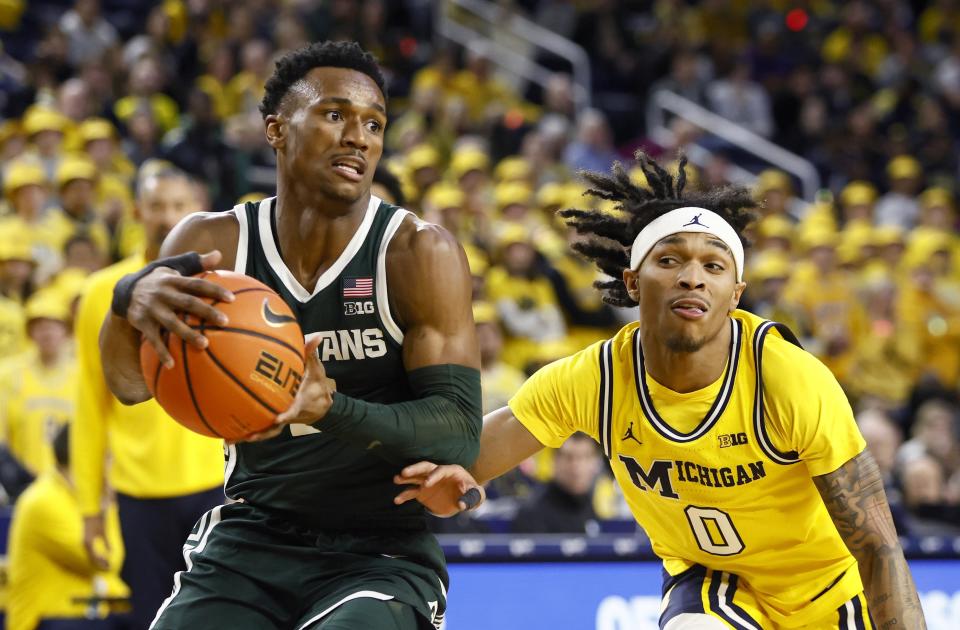 Michigan State guard Tyson Walker (2) drives to the basket past Michigan guard Dug McDaniel (0) during the first half of an NCAA college basketball game Saturday, Feb. 17, 2024, in Ann Arbor, Mich. (AP Photo/Duane Burleson)