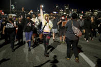 A group marches along the Hawthorne Bridge after meeting at Salmon Street Springs and listening to several Black and Indigenous speakers talk, Friday, April 16, 2021, in Portland, Ore. Police in Portland, said Saturday they arrested several people after declaring a riot Friday night when protesters smashed windows, burglarized businesses and set multiple fires during demonstrations that started after police fatally shot a man while responding to reports of a person with a gun. (Dave Killen/The Oregonian via AP)