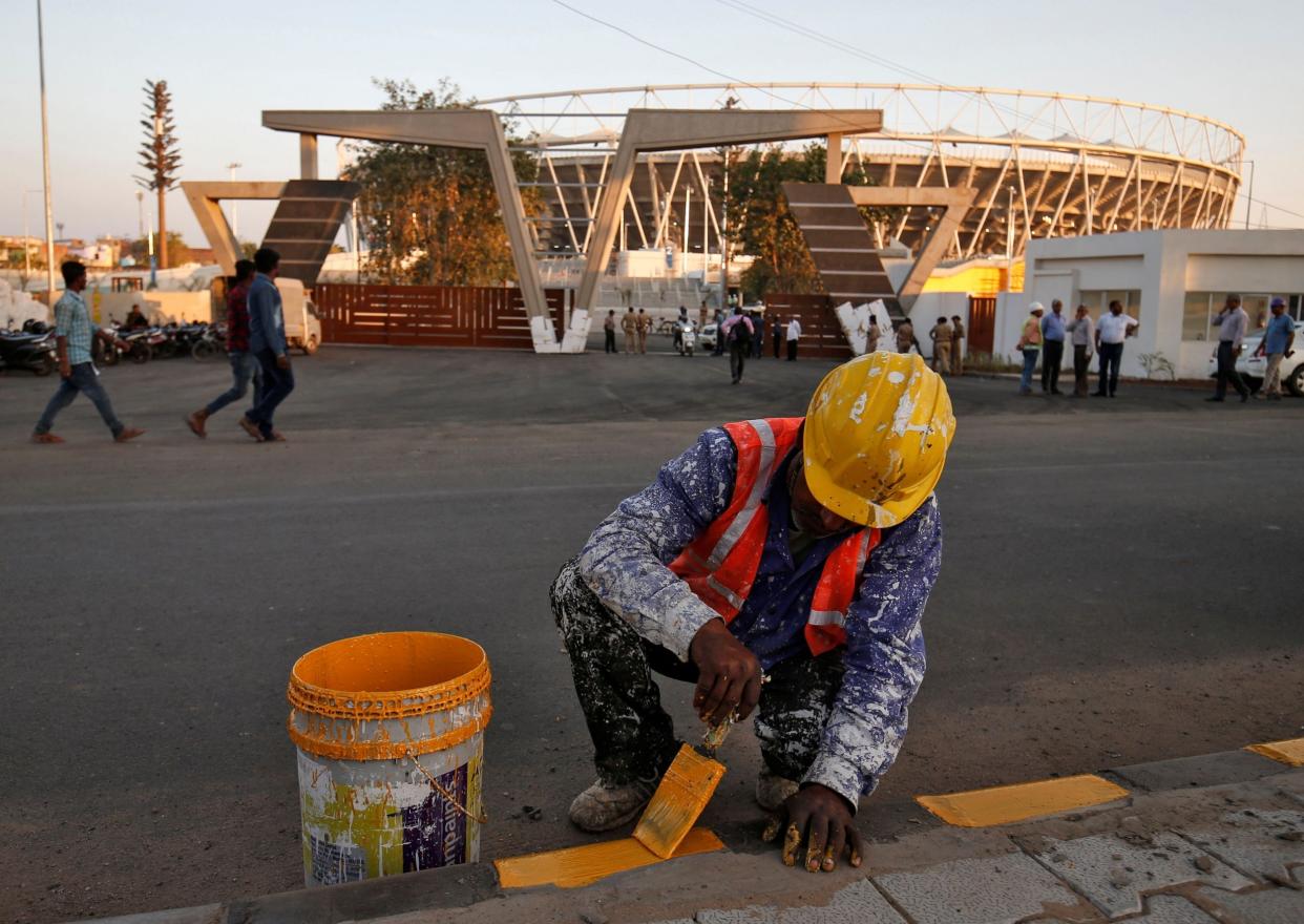 A worker paints a footpath in front of Sardar Patel Gujarat Stadium, where Donald Trump is expected to visit during his upcoming trip to India, in Ahmedabad: REUTERS