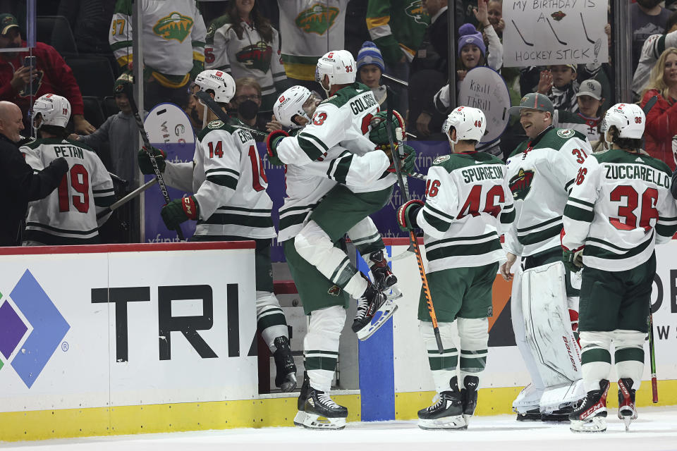 Minnesota Wild defenseman Alex Goligoski (33) jumps into the arms of left wing Marcus Foligno (17) in celebration after Goligoski scored in overtime against the Carolina Hurricanes during an NHL hockey game Saturday, Nov. 19, 2022, in St. Paul, Minn. (AP Photo/Stacy Bengs)