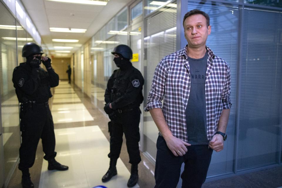 FILE Russian opposition leader Alexei Navalny speaks to the media in front of security officers standing guard at the Foundation for Fighting Corruption office in Moscow, Russia, Thursday, Dec. 26, 2019. The sudden death of Alexei Navalny, the fiercest foe of Russia's President Vladimir Putin, has left Russian opposition with an open wound. Navalny, 47, was the most well-known Kremlin critic at home and abroad, and had arguably the biggest following. (AP Photo, File)