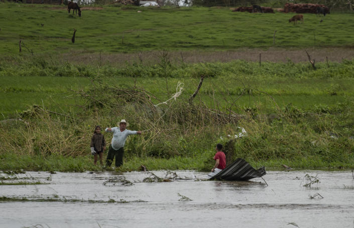 A man recovers pieces of roofing smashed by Hurricane Ian in Pinar del Rio, Cuba, Tuesday, Sept. 27, 2022. (AP Photo/Ramon Espinosa)