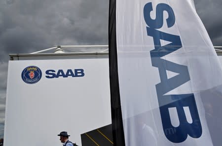 A visitor walks past a Saab Technologies pavilion at Farnborough International Airshow in Farnborough, Britain