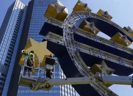 Workers dismantle the large Euro sign sculpture for maintenance, in front of the headquarters of the former European Central Bank (ECB) in Frankfurt, July 6, 2015. REUTERS/Ralph Orlowski