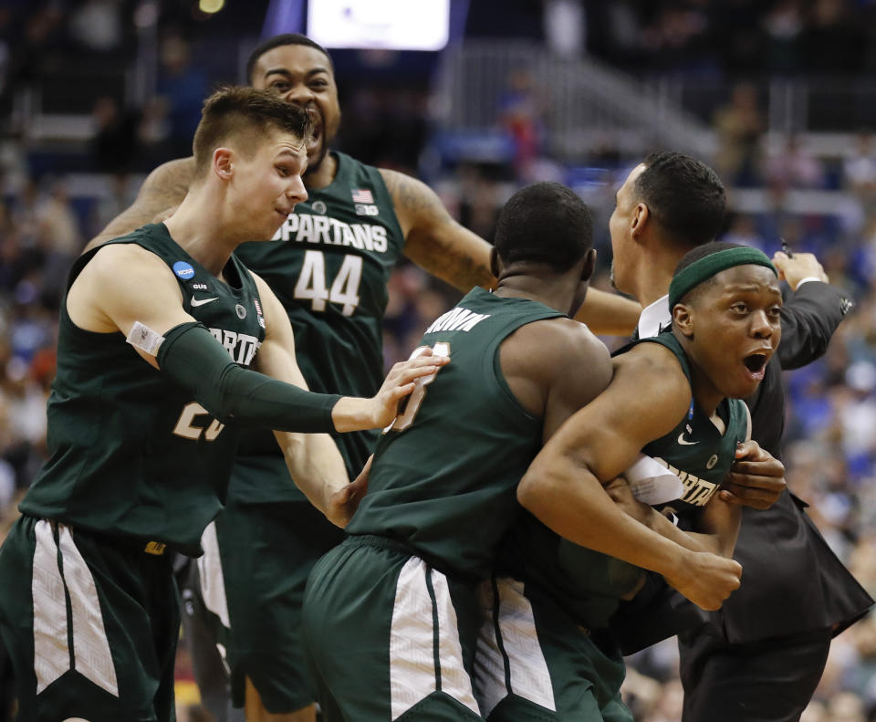 Michigan State guard Cassius Winston, right, celebrates with teammates Matt McQuaid (20), Nick Ward (44) and Gabe Brown (13) after defeating Duke in an NCAA men's East Regional final college basketball game in Washington, Sunday, March 31, 2019. (AP Photo/Patrick Semansky)