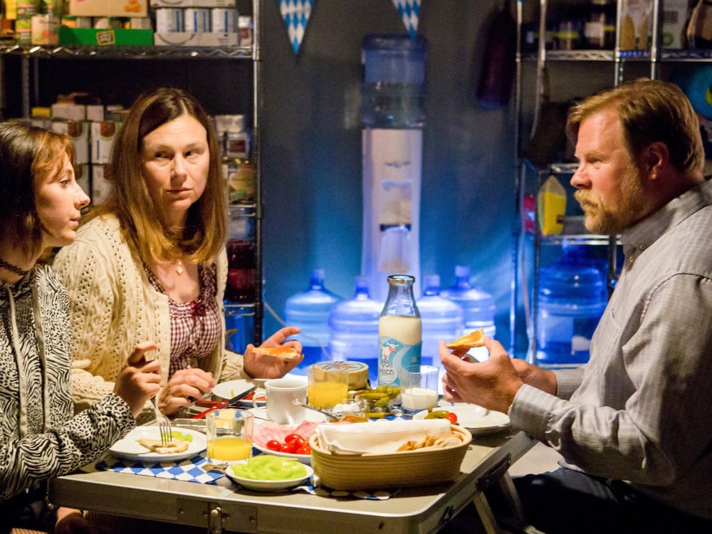 "Alles finster": Marie (Laila Marie Noëlle Padotzke), ihre Mutter Carola (Bettina Mittendorfer) und Jens (Michael A. Grimm) unterhalten sich im Prepper-Keller beim Essen. (Bild: Allegro Film/BR/ORF/Anjeza Cikopano)