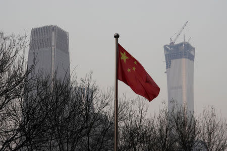 China World Trade Center Tower III (L) and China Zun Tower under construction are pictured behind a Chinese flag in Beijing's central business area, China December 14, 2017. REUTERS/Jason Lee